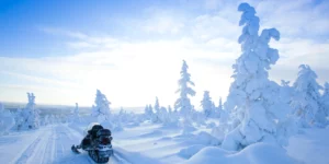 Village lapon sous la neige avec aurore boréale en Laponie finlandaise