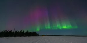 Panorama nocturne de Levi en Laponie finlandaise sous des aurores boréales vertes et violettes