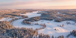 Paysage hivernal de Laponie finlandaise vu du ciel avec forêts enneigées et lac gelé