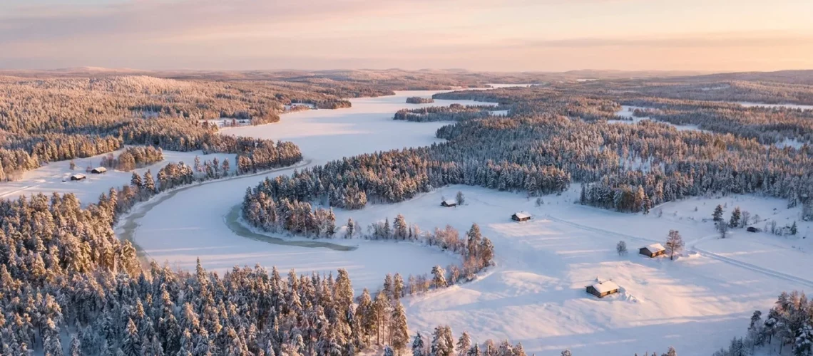 Paysage hivernal de Laponie finlandaise vu du ciel avec forêts enneigées et lac gelé